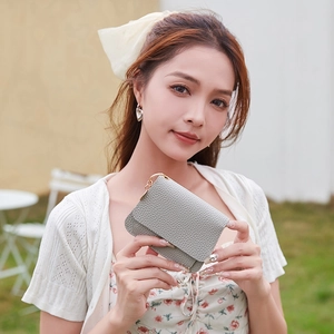 Mini grey litchi grain leather folding wallet with gold clip on natural background