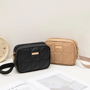 Quilted diamond lattice crossbody bag in black and beige with gold hardware detail