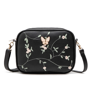 Fashionable black leather crossbody bag with floral embroidery and pink butterfly decor