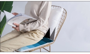Detail of blue geometric cushion on modern gold metal chair with minimalist decor