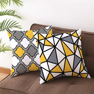 Yellow and grey geometric stripe pillow covers with quatrefoil pattern on a sofa