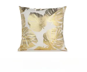 Detail of white square pillowcase with gold monstera leaf foil print and soft texture