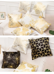 Detail of gold foil stamped pillow covers with botanical and geometric patterns on sofa