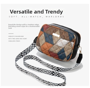 Detail of color-block crossbody bag featuring wide woven strap and dual shoulder straps