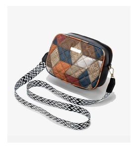 Detail of color-block crossbody bag with geometric leather patchwork and wide woven strap