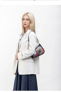 Detail of colorful quilted shoulder bag featuring gold chain strap and textured fabric