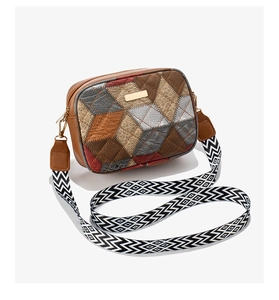 Close-up of color-block camera bag with lychee texture and metallic bar detail