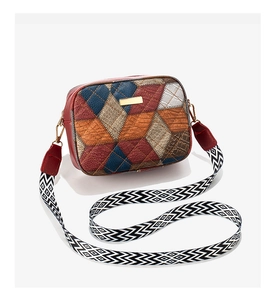 Detail of color-block crossbody bag featuring quilted patterns and adjustable strap