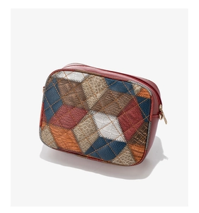 Detail of color-block crossbody bag featuring multi-texture leather and gold zipper