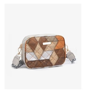 Detail of color-block crossbody bag featuring mixed crocodile and snake textures and wide strap