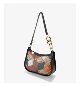 Close-up of quilted colorful plaid underarm bag with gold metal chain and logo detail