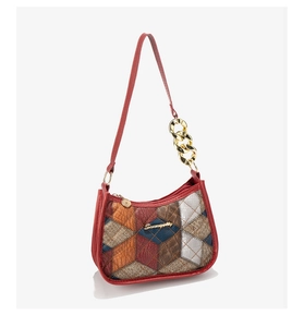 Detail of color-block crocodile texture handbag with gold chain strap and metal logo
