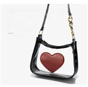 Detailed view of clear PVC crossbody bag with red heart logo and black glossy trim