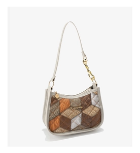Close-up of retro quilted patchwork underarm bag with gold chain and metal logo detail