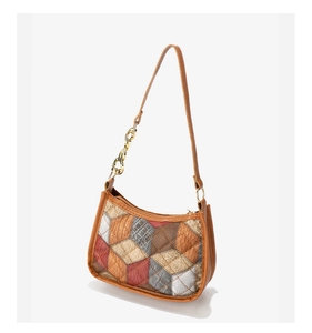 Detailed side view of multi-colored quilted patchwork handbag with gold chain strap