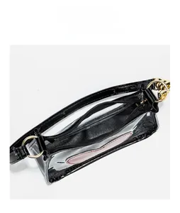 Detail of transparent PVC crossbody bag featuring black patent leather trim and metal zipper