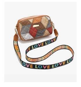 Detail of color-block crossbody bag with pebbled leather texture and LOVE patterned strap