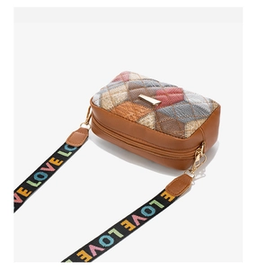 Detail of bohemian quilted crossbody bag with embroidered pattern and LOVE strap