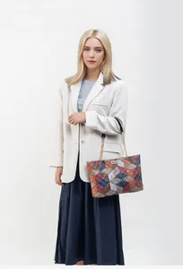 Detail of multi-color patchwork handbag with quilted texture and gold turn-lock closure