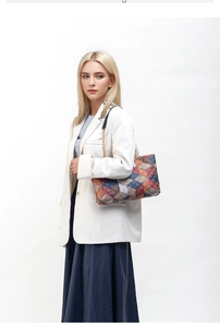 Detail view of stylish color-block quilted handbag with gold chain strap on model