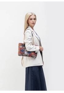 Detail of color-block quilted tote bag with gold chain strap and geometric pattern