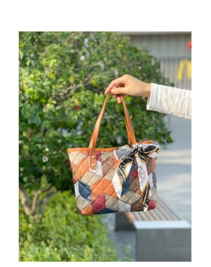 Détail d'un sac cabas à motifs de losanges en cuir grainé avec foulard décoratif