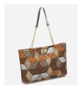 Close-up of geometric paneled tote bag featuring gold twist lock and crocodile texture