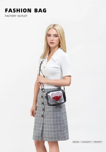 Détail d'un sac caméra transparent en PVC avec cœur rouge et bandoulière à lettres