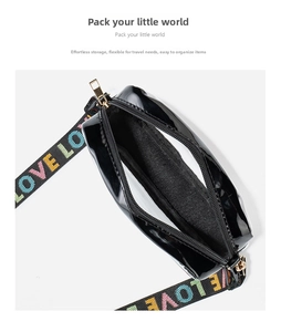 Détail d'un sac bandoulière noir brillant avec sangle jacquard LOVE et fermeture éclair