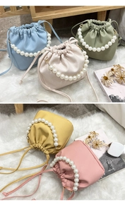 Detail of drawstring bucket bags in pastel colors with elegant pearl bead handles