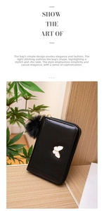 Détail d'un petit portefeuille noir en PU avec emblème papillon et pompon en peluche