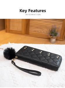 Detail of black quilted long wallet with golden studs and a fluffy pompom keychain charm