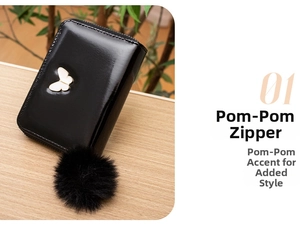 Détail du portefeuille noir en cuir verni avec fermoir papillon et pompon en fourrure