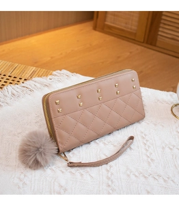 Detail of light brown long zip wallet with diamond quilting and gold studs