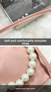 Detail shot of soft shoulder strap and elegant pearl decoration on pink leather bag