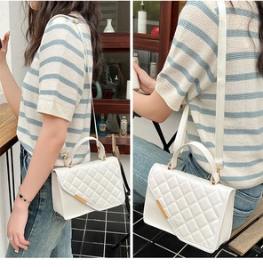 Lifestyle-Foto einer weißen Stepptasche mit Metallbesatz und breitem Gurt