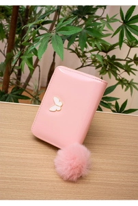 Portefeuille rose en cuir verni avec boucle papillon et breloque pompon en peluche