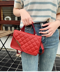 Detail der roten gesteppten Tasche mit goldener Hardware und Web-Schultergurt