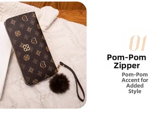 Detail of long brown purse with vintage floral pattern and fur pompom zipper pull
