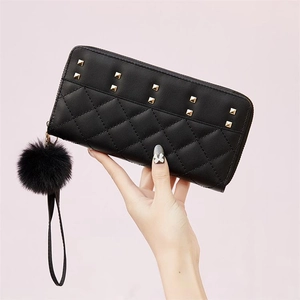 Women's long black zip wallet featuring quilted diamond pattern and golden stud accents