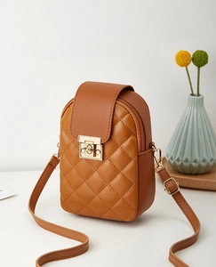 Detailed view of brown quilted crossbody phone bag with gold metal twist lock and strap