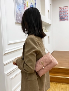 Détail du sac à bandoulière matelassé rose avec pendentif couronne dorée et perle