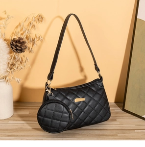 Dettaglio della borsa trapuntata nera con finiture dorate e mini pochette tonda