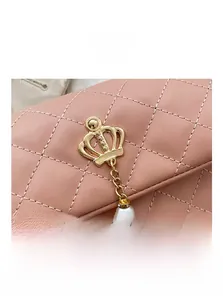 Détail du sac matelassé rose avec fermoir couronne dorée et pendentif en perles