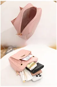 Detailed view of pink quilted crossbody phone bag showing spacious multi-pocket interior