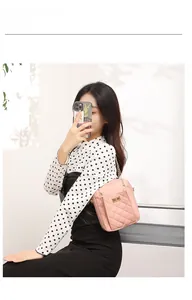 Detail showing pink quilted mini crossbody bag with golden chain and metal turn-lock closure