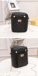 Detail of a black quilted mini crossbody bag with gold chain strap and turn-lock closure