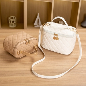 Elegant quilted bucket bag in beige and khaki with gold hardware and shoulder strap