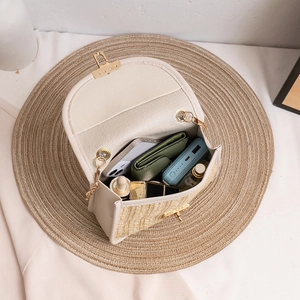 Beige woven straw crossbody bag with gold chain strap and spacious interior for phone