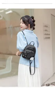 Détail d'un mini sac à dos en cuir PU noir avec imprimé marguerites et texte blanc